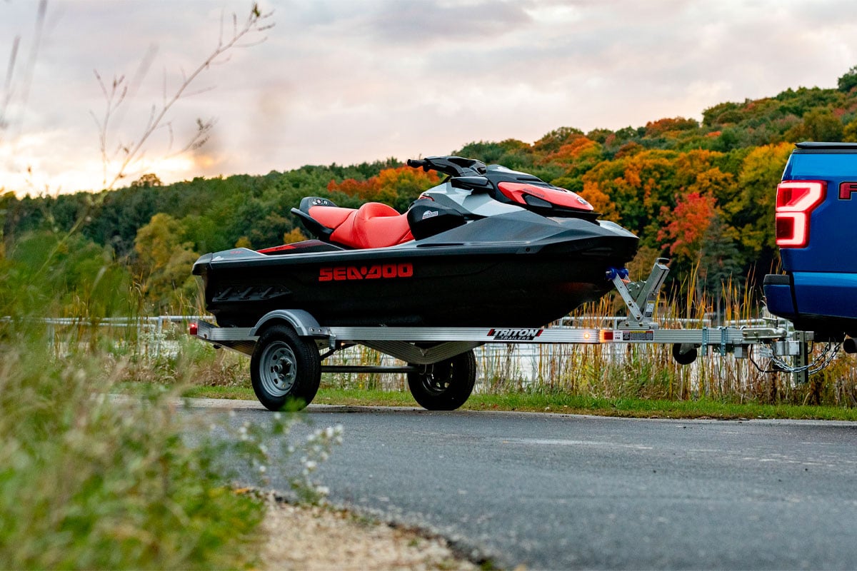 Open Triton LT Series Trailer Being Towed With Jet Ski On It